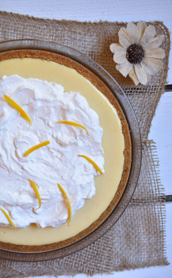 A whole Lemon Cream Pie topped with fresh whipped cream lemon zest