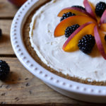 A whole blackberry peach cream cheese pie garnished with fruit