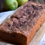 A loaf of Pear Almond Bread with pears in the background