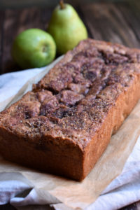 A loaf of Pear Almond Bread with pears in the background