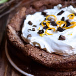 Fallen Chocolate Cake topped with orange zest whipped cream and chocolate curls