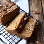 Spiced Banana Bread with bananas and pecans in the background