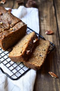 Spiced Banana Bread with bananas and pecans in the background