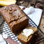 Spiced Banana Bread with bananas and pecans in the background