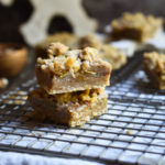 Spiced Pear Crumb Bars on a cookie rack with more and a big wooden snowflake in the background