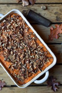 Pecan Yam Casserole with a nutmeg grater and fall leaf in the background