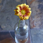 A bottle with a fall yellow and orange flower