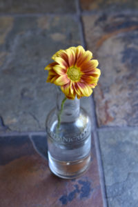 A bottle with a fall yellow and orange flower