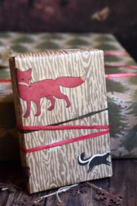 A woodsy wrapping paper with a red fox and skunk on the front