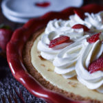 Classic Cheesecake Pie with Strawberry with heart plates in the background