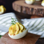 Caper, Dill, Onion Eggs with many on a wood board in the background