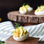 Caper, Dill, Onion Eggs with many on a wood board in the background