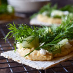 Hummus Dill Snack Crackers on a wire rack with others in the background