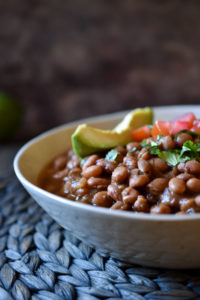 Instant Pot Pinto Beans topped with avocado, diced tomato, and cilantro