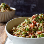 Lemon Vegetable Quinoa Salad with a wood serving spoon and a smaller bowl of salad in the background.