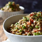 Lemon Vegetable Quinoa Salad with a wood serving spoon and a smaller bowl of salad in the background.