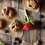 An overview of Blueberry Coconut Clove Scones with blueberries and red and blue flowers