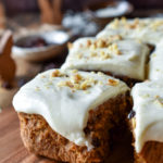 A piece of Bourbon Orange Spiced Carrot Cake with tiny wood bunnies and more in the background
