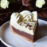 A slice of Orange Chocolate Cream Pie with spring flowers to the side.