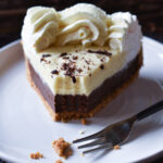 A slice of Orange Chocolate Cream Pie with a bite missing from a fork and spring flowers in the background.