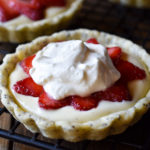 A Strawberry with Vanilla Bean Cream Tart with another tart in the background.
