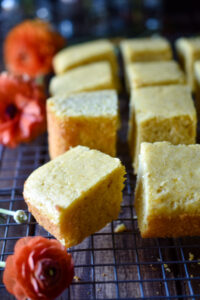 Pieces of Orange Spiced Cornbread and orange flowers to the side.