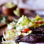 A close up of an unfolded Roasted Portobello Mushroom Tacos with another in the background.