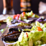 A close up of an unfolded Roasted Portobello Mushroom Tacos with another in the background.