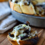 A Sautéed Mushroom Garlic Crostini with more in a tin pan in the background